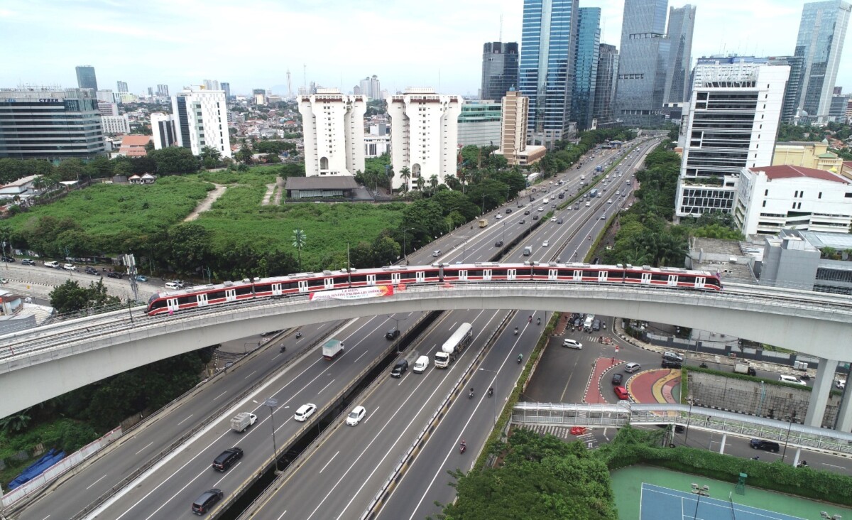 LRT Jabodebek berjalan menyusuri rel layang yang melintasi ruas jalan tol di Jakarta. (Foto: kai.id)   