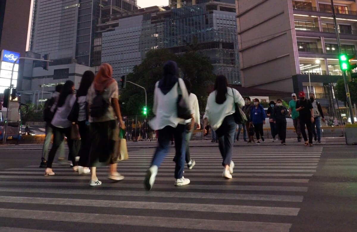 Pekerja sedang menyeberang jalan di kawasan perkantoran Jalan Sudirman, Jakarta Pusat,. Senin (30/10/2023). Pekerja usia muda termasuk kelompok yang rentan terjerat utang pinjaman online. (Foto: Quarta.id/Eros Amil Maj)     