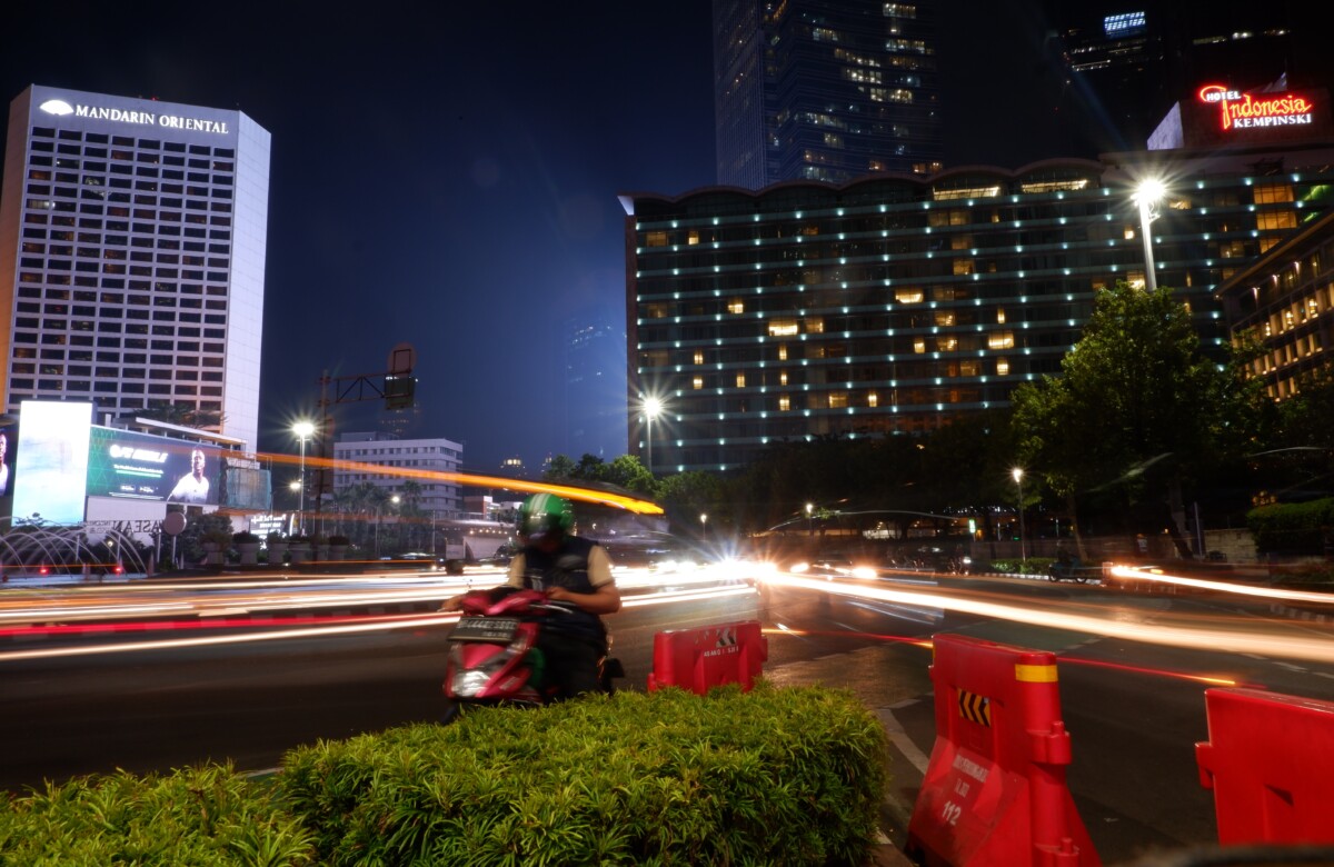 Seorang pengemudi ojek online sedang memeriksa pesanan di telepon selulernya di kawasan Bundaran Hotel Indonesia, Jakarta Pusat, Senin (30/10/2023).  (Foto: Quarta.id/Eros Amil Maj)