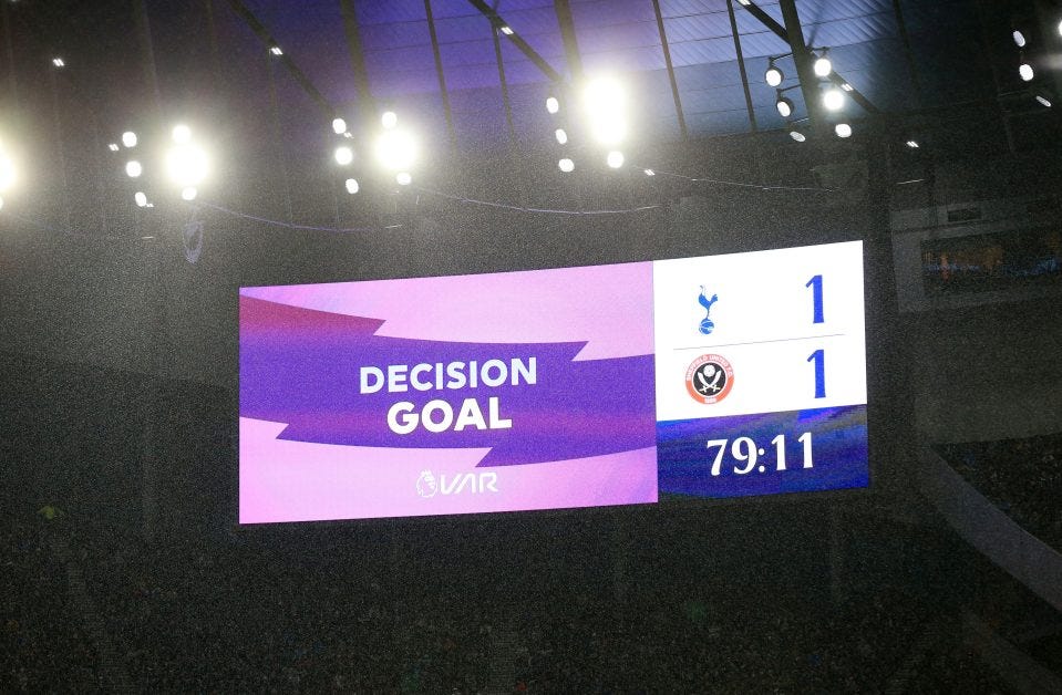 Layar raksasa menampilkan hasil analisis video assistant referee (VAR) di Tottenham Hotspur Stadium. Aturan VAR terancam dihapus pada kompetisi Premier League musim depan.    (Foto: hilarispublisher.com)
